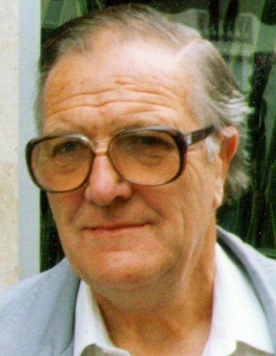 Portrait image of Eric Gibbard - CEO of Burghleighfield Foundry wearing glasses, a white shirt and pale blue-grey jacket.